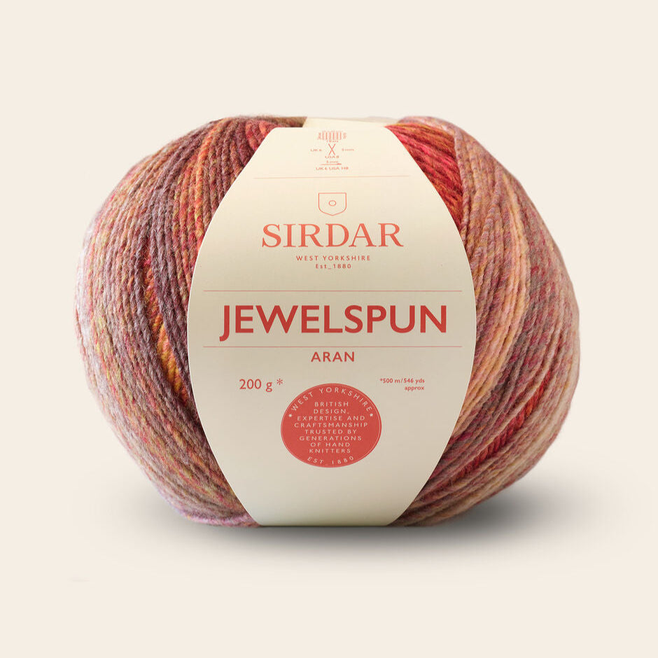 Sirdar Jewelspun Aran yarn ball with label on a beige background